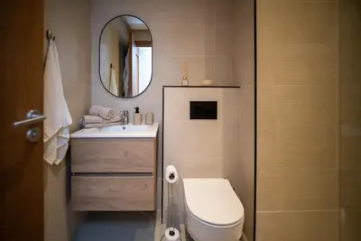 a bathroom with a toilet and a sink and a mirror at Gauthier Luxe , 1BR Apart- Comfort & Style in Casa in Casablanca
