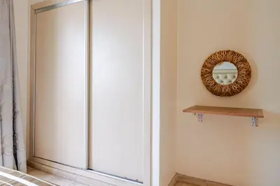a glass door in a room with a mirror at Appartement avec terrasse en plein centre de ville in Casablanca