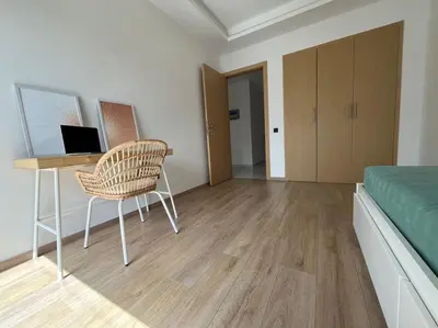 a bedroom with a desk and a bed and a chair at Appartement Les pieds dans l'eau in Oulad Kerroum