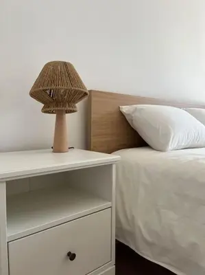a lamp on a night stand next to a bed at Appartement Les pieds dans l'eau in Oulad Kerroum