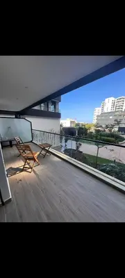 a chair on a balcony with a view of a building at Cosy studio avec grande terasse et parking CFC in Casablanca