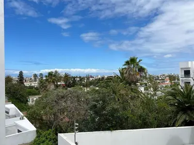 a view of a city with palm trees and a building at Appartement vaste et lumineux, Oasis in Casablanca
