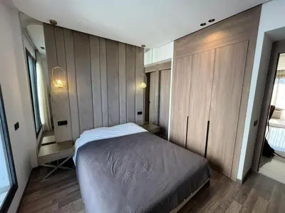 a bedroom with a bed and wooden cabinets at Appartement vaste et lumineux, Oasis in Casablanca