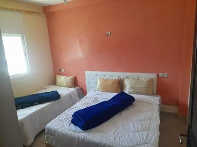 a room with two beds with blue pillows on them at Auberge les Roches in Al Haouamed