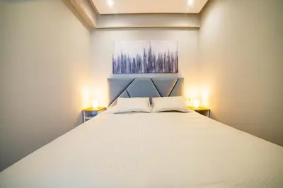 a bedroom with a large white bed with two lamps at Studio au coeur de Casablanca in Casablanca