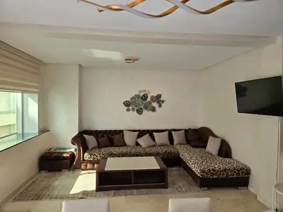 a living room with a couch and a table at Superbe appartement meublé, lumineux et idéalement situé in Casablanca