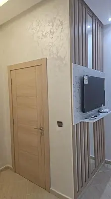 a room with a door and a television on a wall at Naj'Appartement de charme in Temara