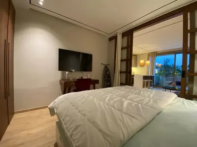 a bedroom with a bed and a flat screen tv at Findy Maarif avec jardin privé in Maarif