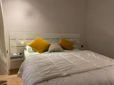 a white bed with yellow pillows in a bedroom at Findy Maarif avec jardin privé in Maarif