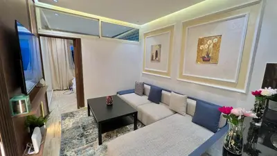 a living room with a couch and a tv at Stylish 2BR Appartement Central - 5 min Casa port in Casablanca