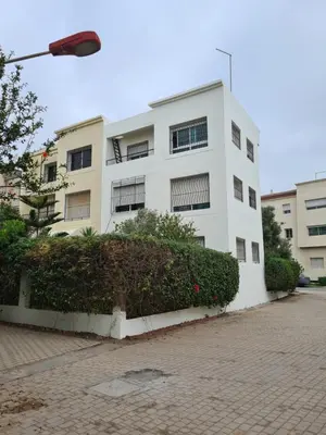 a white building with a hedge in front of it at Belle maison à Harhoura proche de la plage in Rabat