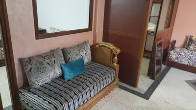 a couch with a blue pillow sitting in a room at Msn in Rabat