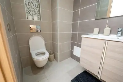 a small bathroom with a toilet and a sink at Sophisticated 3BR with Ample Space & Top Amenities in Rabat