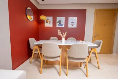 a dining room with a white table and chairs at Prestigia Gem Spacious 3BR Flat in Hay Riad in Rabat