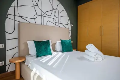 a bedroom with a large white bed with green pillows at Prestigia Gem Spacious 3BR Flat in Hay Riad in Rabat