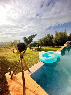 a swimming pool with four blue inflatables on it at Ferme de luxe in O Ben Slimane