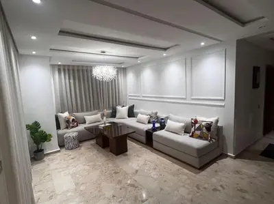 a living room with couches and a chandelier at Appartement de luxe à Casablanca in Aïn Sebaa