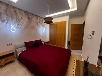 a bedroom with a red bed in a room at Appartement de luxe à Casablanca in Aïn Sebaa