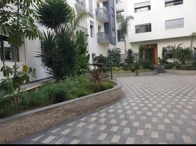 a courtyard in front of a building with plants at Appartement de luxe à Casablanca in Aïn Sebaa