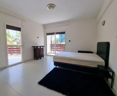 a white room with a bed and a large window at Appartement lumineux plein-centre, parfait pour explorer ! in Casablanca