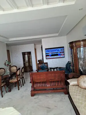 a living room with a couch and a table and chairs at les sables d'or in Temara