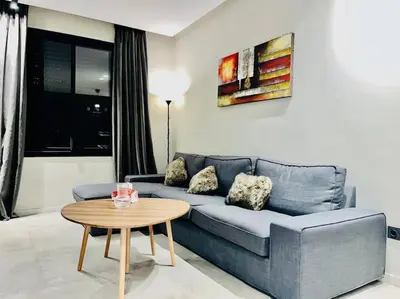 a living room with a blue couch and a table at Studio Raffiné en Plein Gauthier in Casablanca