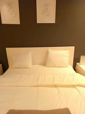 a bed with white sheets and pillows in a bedroom at Studio Raffiné en Plein Gauthier in Casablanca