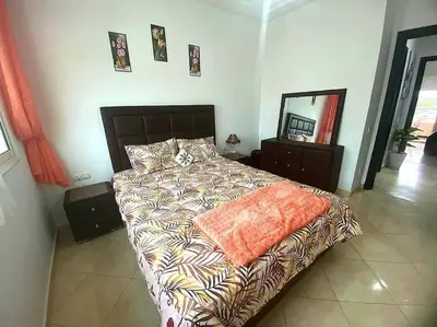 a bedroom with a bed with a comforter and a mirror at Appartement, Salam Beach in Pont Blondin