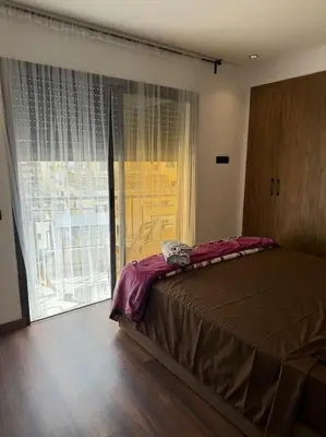 a bedroom with a bed and a large window at Chic studio à Maarif, near CFC in Casablanca