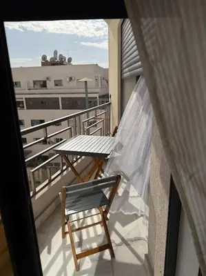 a balcony with a table and a chair on a balcony at Chic studio à Maarif, near CFC in Casablanca