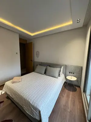 a bedroom with a large bed and a table at Apparemment luxueux casablanca in Casablanca
