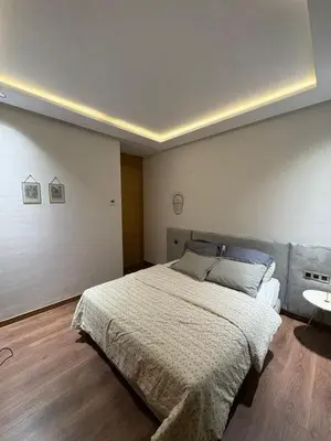 a bedroom with a large bed and a table at Apparemment luxueux casablanca in Casablanca