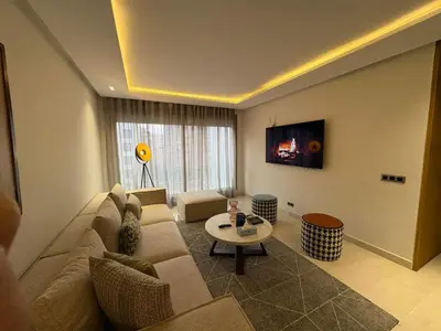 a living room with a couch and a table at Apparemment luxueux casablanca in Casablanca