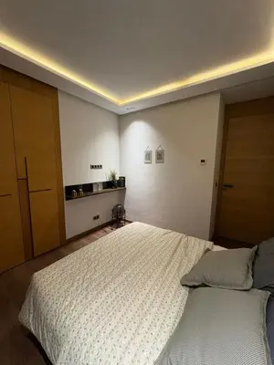 a bedroom with a large bed and a wooden door at Apparemment luxueux casablanca in Casablanca