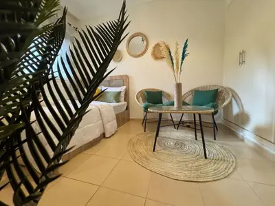 a living room with a table and chairs and a couch at appartement exceptionnel vue sur mer pour famille uniquement in Rabat