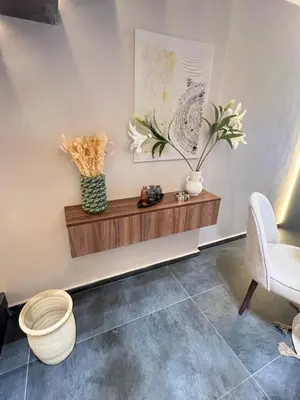 a living room with a wooden shelf and a chair at Quart des hôpitaux duplex luxe et sérénité in Casablanca