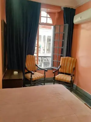 a bedroom with two chairs and a bed and a window at Hôtel Volubilis in Casablanca
