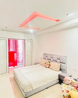 a bedroom with a large bed and a couch at ONOMSUIT-Appartement en plein centre ville RABAT in Rabat