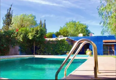 a swimming pool with a slide in front of a house at Espace happy village settat in Settat