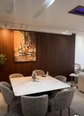 a dining room with a white table and chairs at أجمل شقة الوفاق in Temara