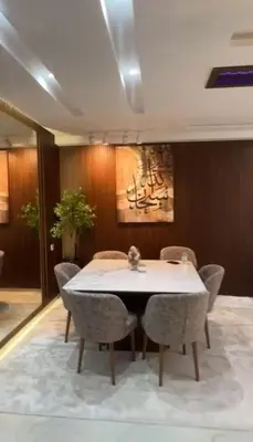 a dining room with a white table and chairs at أجمل شقة الوفاق in Temara