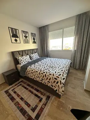 a bedroom with a bed with a black and white comforter at Cozy apartment in Mohammedia in Mohammedia