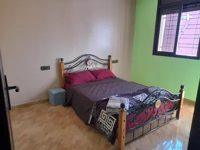 a bedroom with a bed in a room with green walls at Apartament Ines in Skhirat