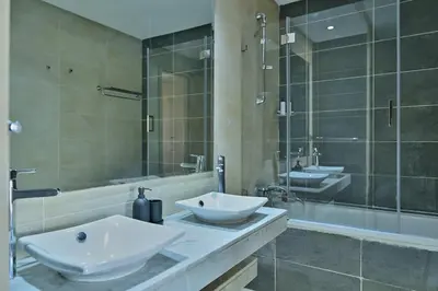 a bathroom with two white sinks and a shower at YourPlace - Modern, Spacious 3BR in Prestigia in Rabat