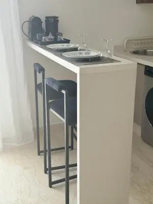 a counter with two stools at a kitchen island at 38 Studio luxueux- Corniche à 5 min in Casablanca