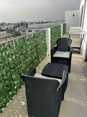 two chairs and a table on a balcony at 47 Appartement luxueux proche de la mer in Casablanca