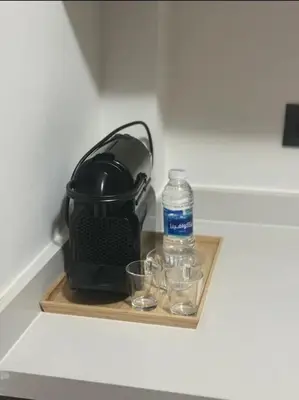 a bottle of water and two glasses on a tray at 47 Appartement luxueux proche de la mer in Casablanca
