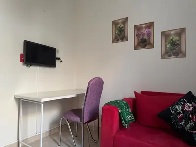 a living room with a red couch and a table at Appartement calme in Tamaris