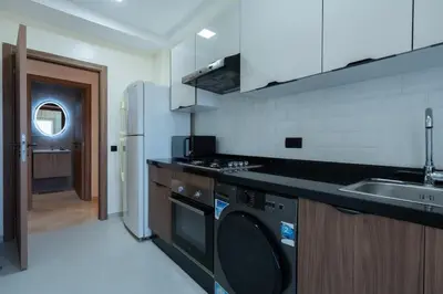a kitchen with a washer and a sink and a refrigerator at Appartement Prestige et Confort in Casablanca