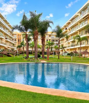 a swimming pool in front of a large apartment building at Les Jardins De Bouznika GHA4 in Bouznika